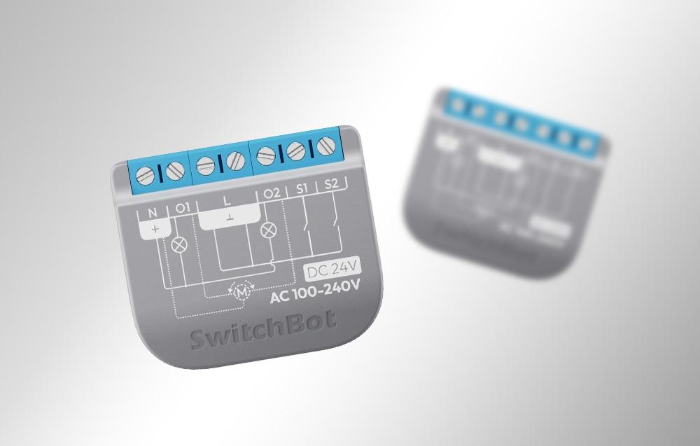 Δύο μονάδες SwitchBot Relay Switch 2PM που απεικονίζονται από διαφορετικές οπτικές γωνίες με ορατές τις συνδέσεις και τα διαγράμματα καλωδίωσης